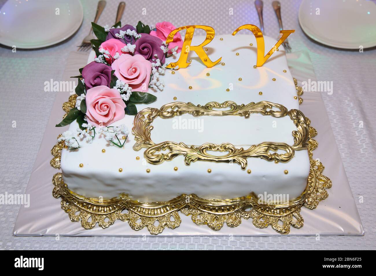 Un posto da scrivere sulla torta. Le lettere R e V in giallo. Fiori rosa  sulla torta. Torta rettangolare bianca Foto stock - Alamy