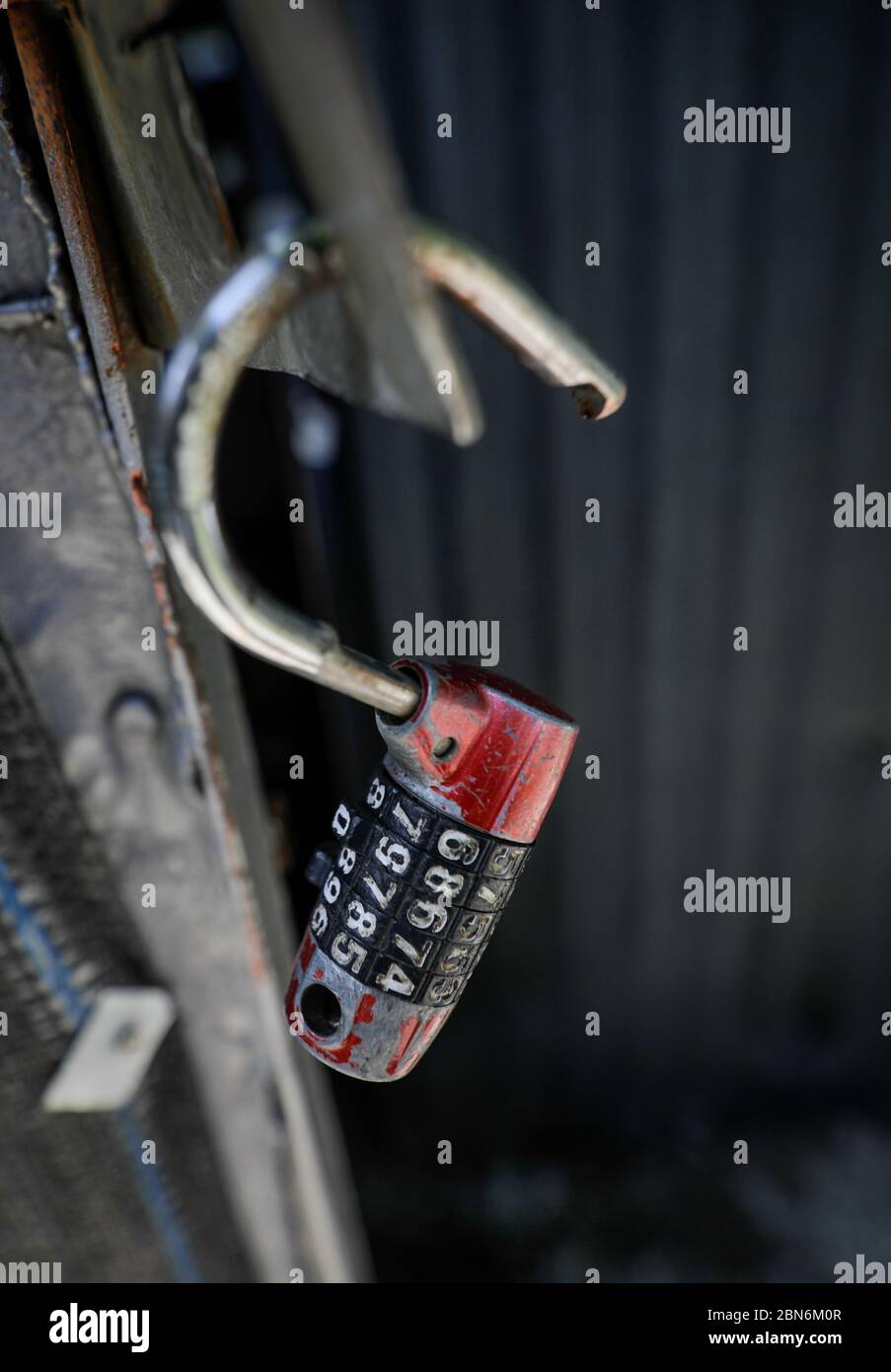 Immagine a profondità di campo bassa (messa a fuoco selettiva) con un vecchio lucchetto aperto a cifone. Foto Stock