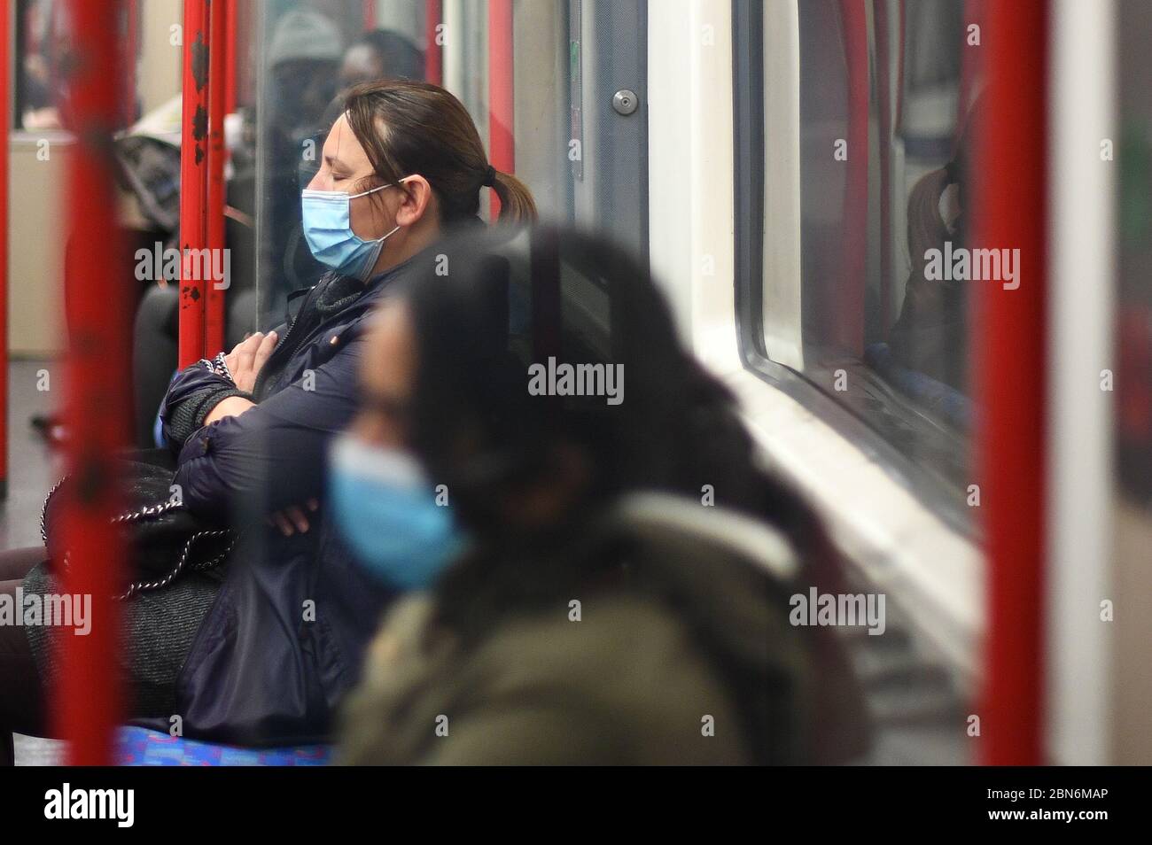 Un passeggero indossa una maschera facciale su un treno della metropolitana Central Line di Londra, dopo l'annuncio dei piani per far uscire il paese dalla fermata. Foto Stock