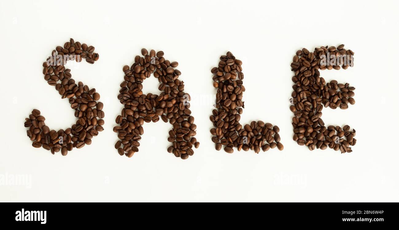 I chicchi di caffè hanno la forma di una vendita di lettere su sfondo bianco isolato Foto Stock