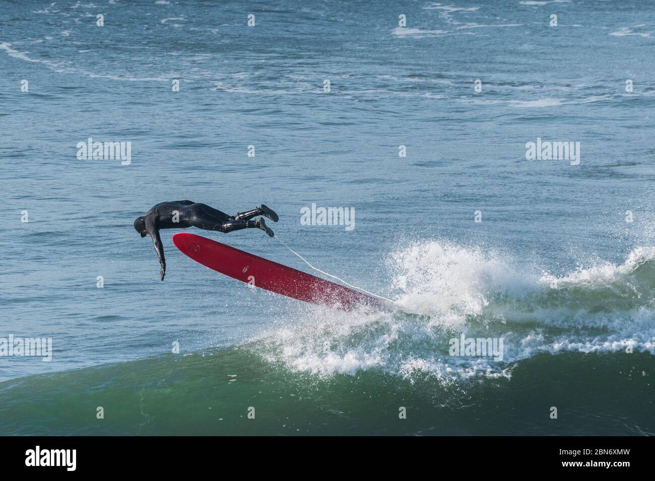 Un surfista che si dilata a South Fistral a Newquay in Cornovaglia. Foto Stock