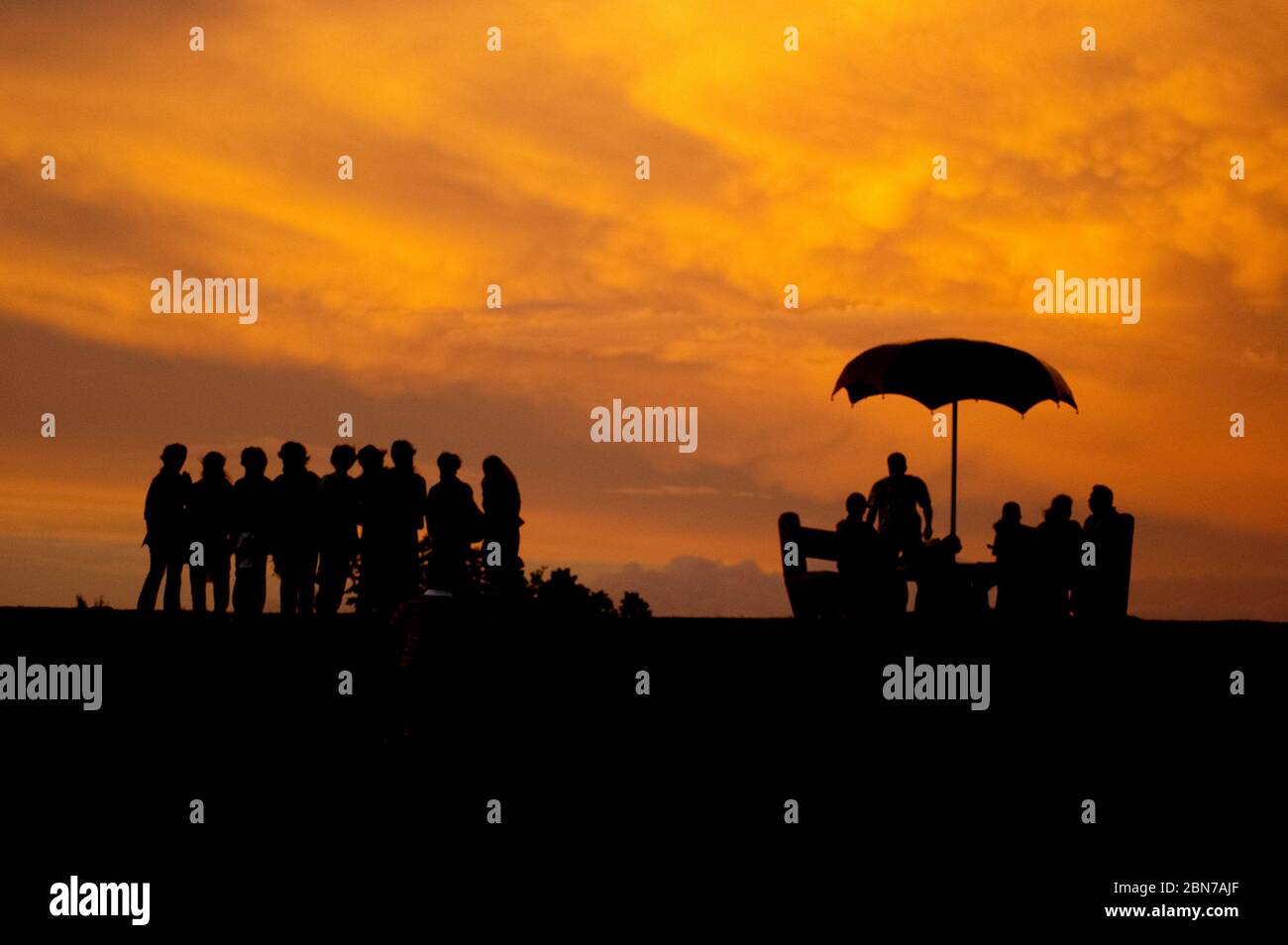 Un gruppo di persone che si pongono per una foto durante l'ora buia del tramonto Foto Stock