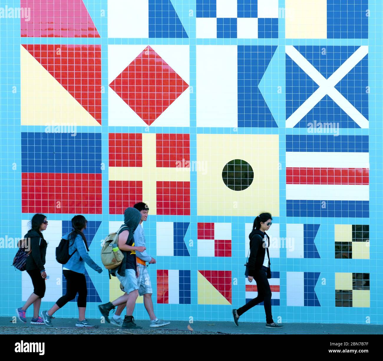 La gente cammina davanti a un muro di piastrelle con bandiera marittima design Los Angeles CA Foto Stock