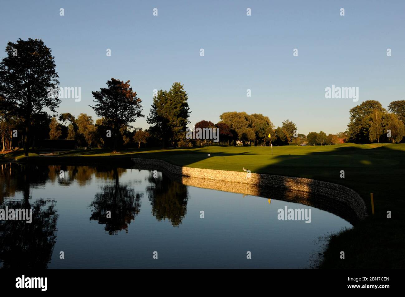 Vista sul lago al 18th Green e Fairway con ombre; Ham Manor Golf Club, Angmering, Sussex, Inghilterra Foto Stock
