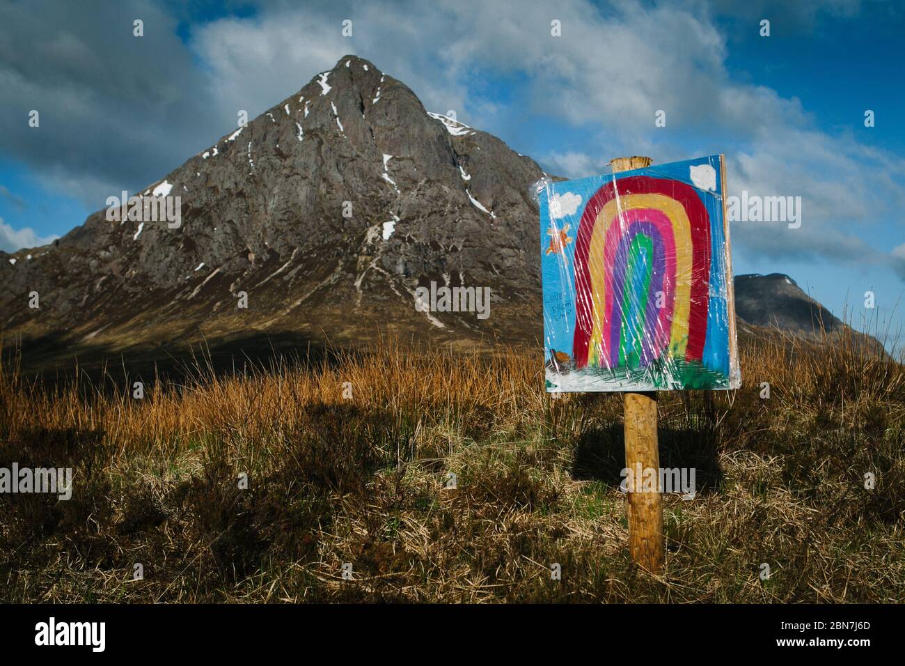 Un arcobaleno dipinto su un segno di un bambino, di fronte al Buachaille Etive Mor, a Glencoe, Scozia, durante il blocco pandemico di Corona Virus. Foto Stock