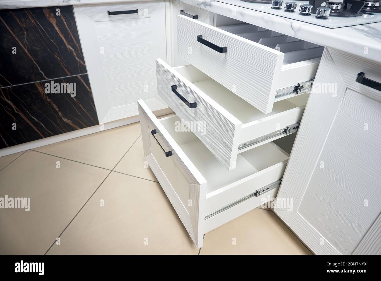 Soluzione per mettere gli utensili da cucina in cucina moderna - orizzontale scorrevole cassetti scaffali di stoccaggio in armadio per utensili da cucina pentole sotto Foto Stock