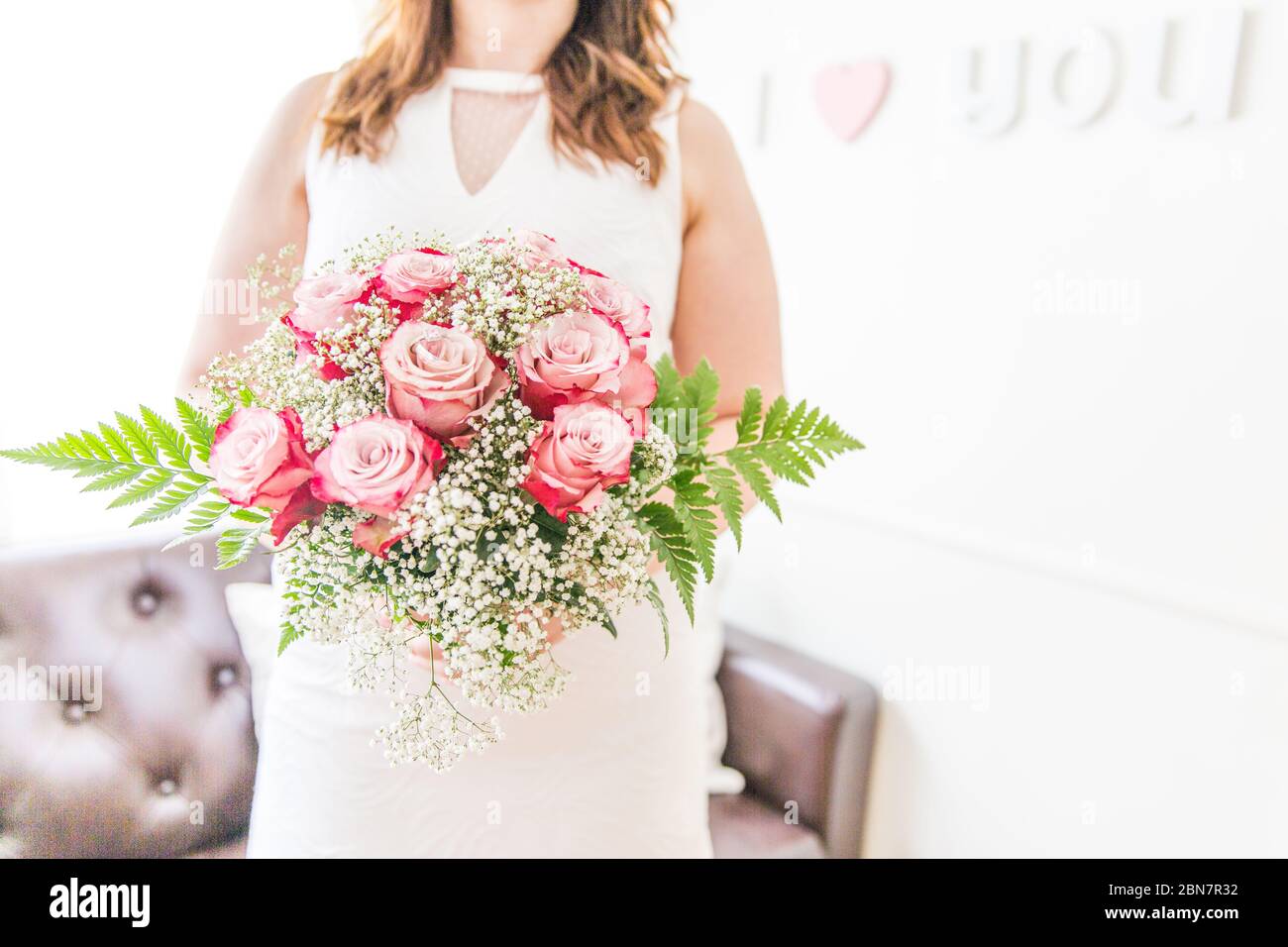 Sposa con rose rosa fresche, gypsophila e bouquet di Fern Foto Stock