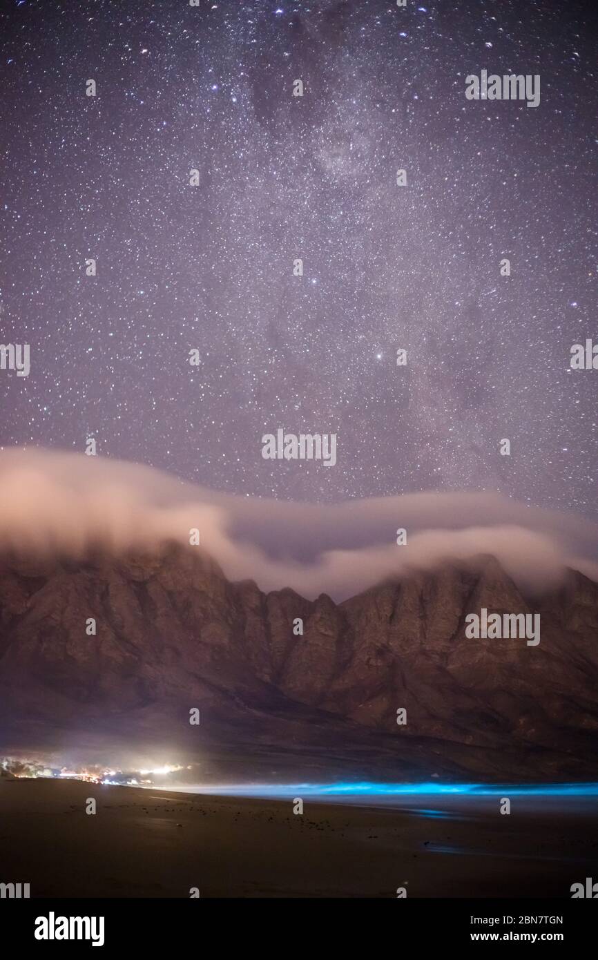 Gli organismi plancton bioluminescenti nell'acqua al largo di Kogel Bay, Capo Occidentale, Sud Africa, emettono un bagliore blu quando l'azione delle onde aggita l'acqua. Foto Stock