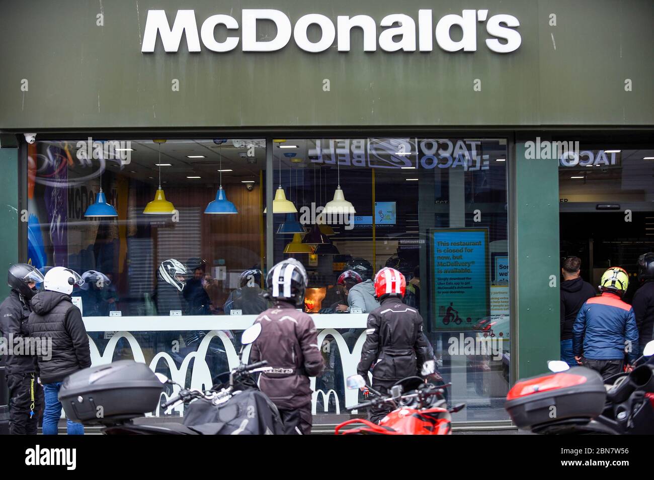 Londra, Regno Unito. 13 maggio 2020. I piloti di consegna attendono gli ordini mentre il ristorante fast food McDonald's di Harrow riapre per "McDelivery" durante la pandemia di coronavirus in corso. Il ristorante e' uno dei 14 nel Regno Unito che la catena sta riaprendo parzialmente con un menu' limitato e solo consegna. La consegna è soddisfatta da terzi come Uber Eats e Deliveroo. Credit: Stephen Chung / Alamy Live News Foto Stock