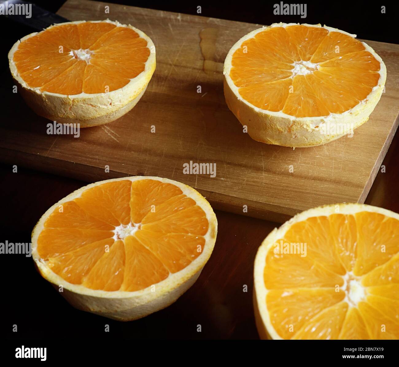 Cibo ancora vita: Metà arance tagliate e sbucciate pronte per spremere per il succo Foto Stock