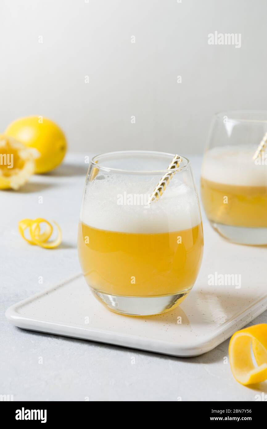Due cocktail acini con ingredienti, succo di limone, albume d'uovo su bianco. Spazio di copia. Foto Stock