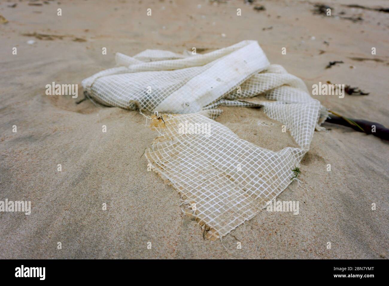 Sacchetto di plastica su una sabbia dopo la tempesta del mare. Spazzatura nella natura. Inquinamento ambientale. Problema ecologico Foto Stock