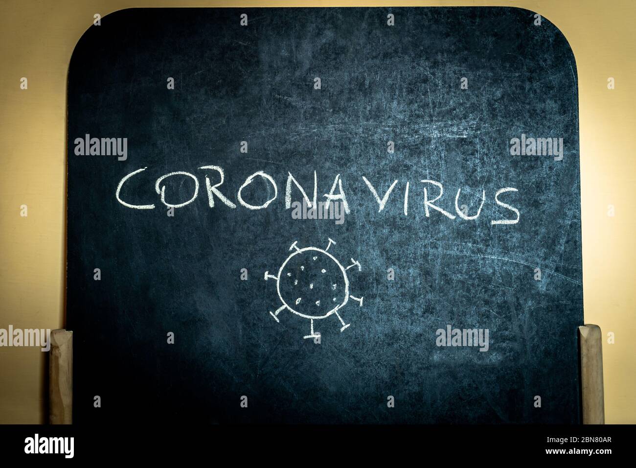 lavagna con la scrittura e il disegno del coronavirus da parte di un bambino. Foto Stock