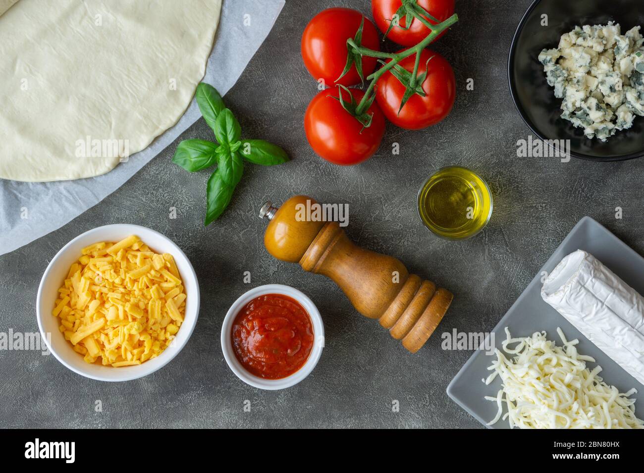 Ingredienti per quattro pizza al formaggio sul tavolo. Pranzo o cena vegetariani. Vista dall'alto. Foto Stock