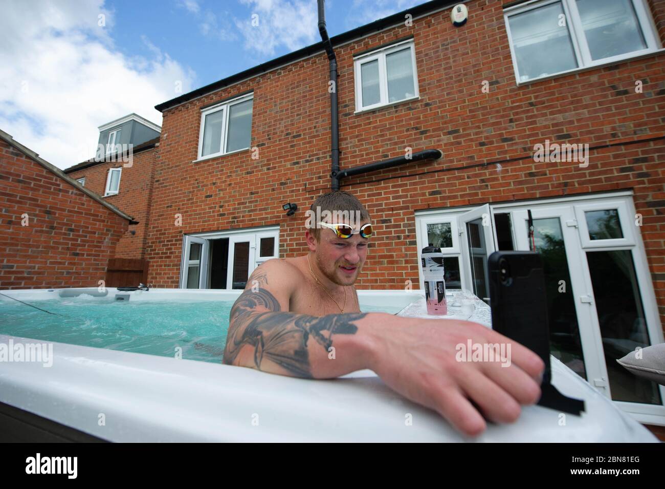 Il nuotatore britannico Adam Peaty parla di allenatore Mel Marshall mentre si allena a casa sua a Loughborough in piscina fornita da Jacuzzi in collaborazione con le vasche idromassaggio Bedfordshire per consentire ai nuotatori olimpici del GB di continuare ad allenarsi a casa per Tokyo 2021 durante l'attuale blocco del Regno Unito. Foto Stock