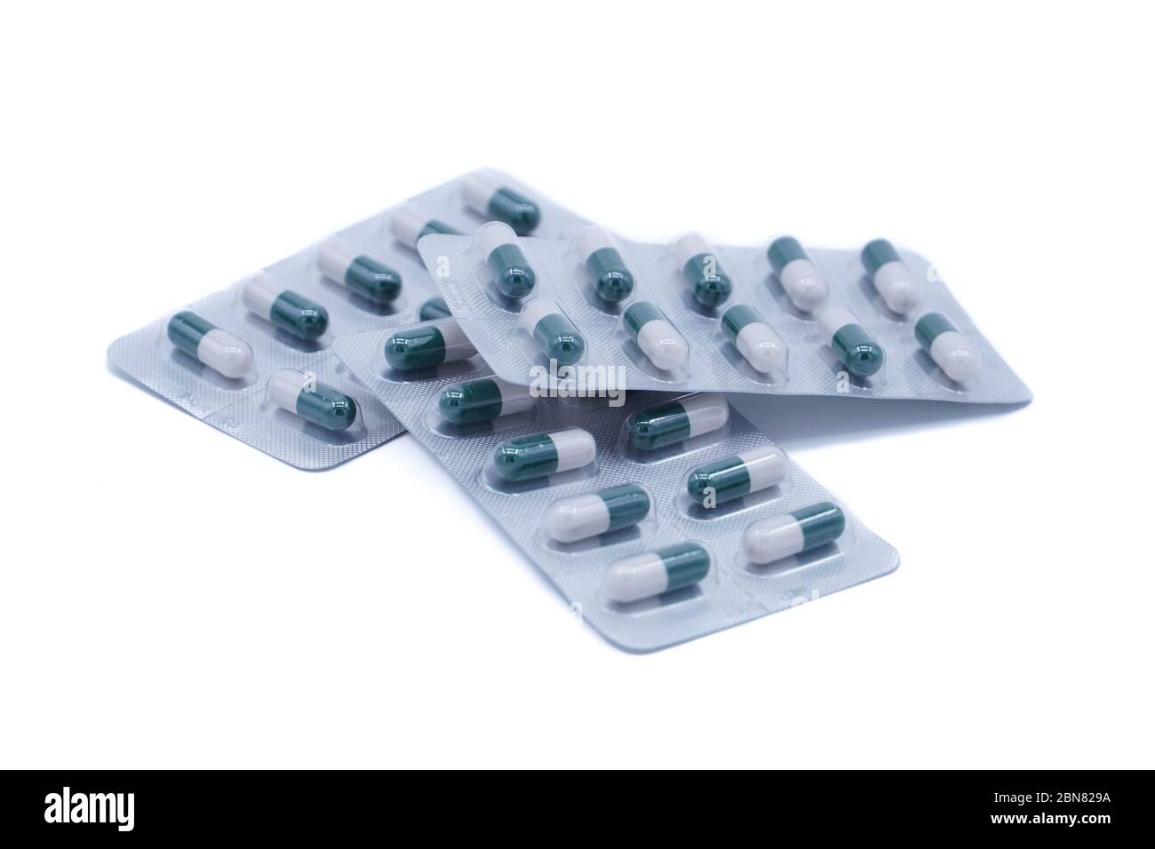 Pillola medica verde-bianca in -sfondo bianco Foto Stock