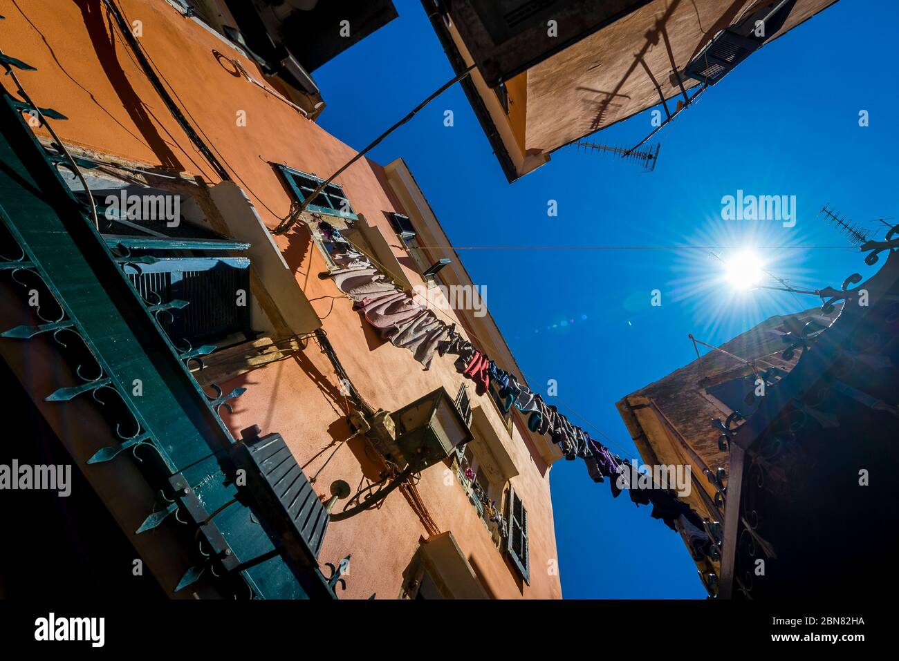 Lavaggio colorato appeso ad asciugare tra gli edifici di Corfù, Grecia Foto Stock