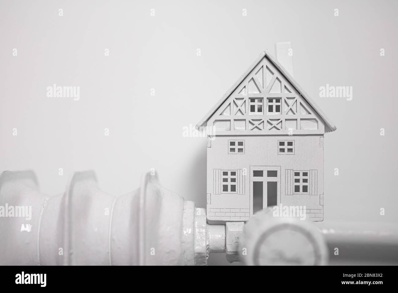 Un riscaldatore con casa su parete bianca Foto Stock