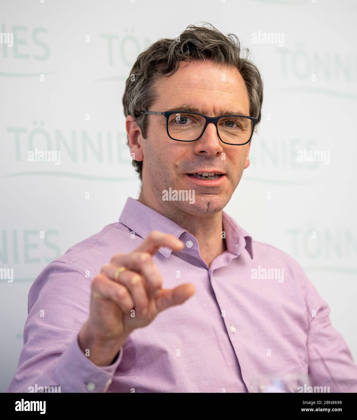 13 maggio 2020, Renania settentrionale-Vestfalia, Rheda-Wiedenbrück: Gereon Schulze Althoff, responsabile della gestione della qualità e degli affari veterinari di Tönnies, interviene in una conferenza stampa. L'argomento era costituito dai campioni valutati finora dopo i test per le infezioni da corona nella Tönnies più grande industria di lavorazione della carne della Germania. Lo stato della Renania settentrionale-Vestfalia aveva ordinato, dopo un accumulo di persone infette da corona, che tutti i dipendenti dei macelli dello stato fossero sottoposti a test. Foto: David Inderlied/dpa Foto Stock