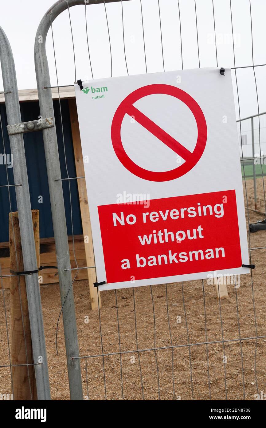 Un cartello di avvertimento su un cantiere che dice 'no Reversing without a banksman', Inghilterra, Regno Unito Foto Stock