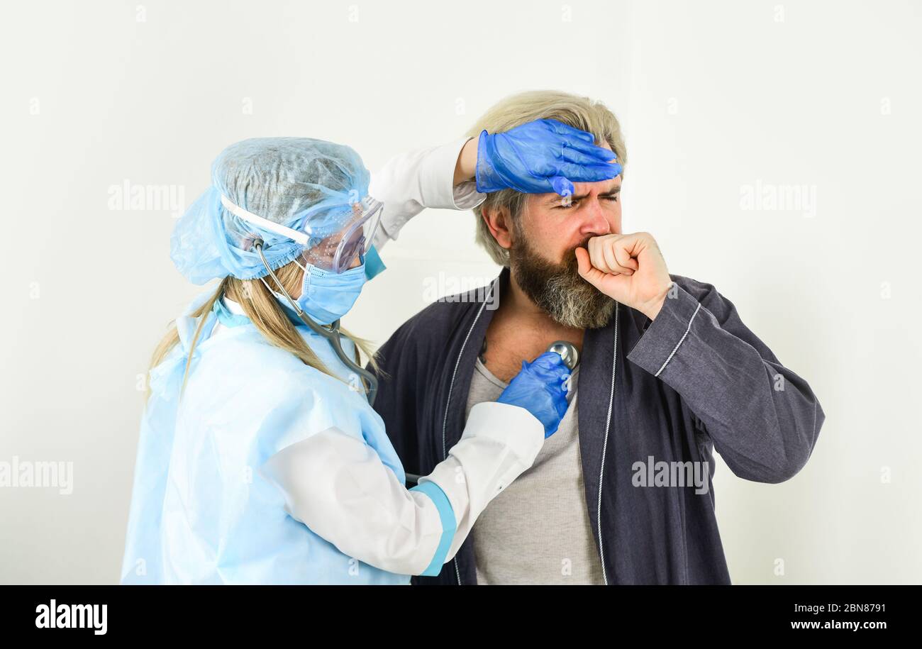 uomo e medico in guanti protettivi e maschera respiratore. infermiere donna esaminare paziente. rischio biologico. Avere Cold Virus catturato malattia di influenza. Ascolta il battito cardiaco e misuri la temperatura. Rimani a casa. Foto Stock