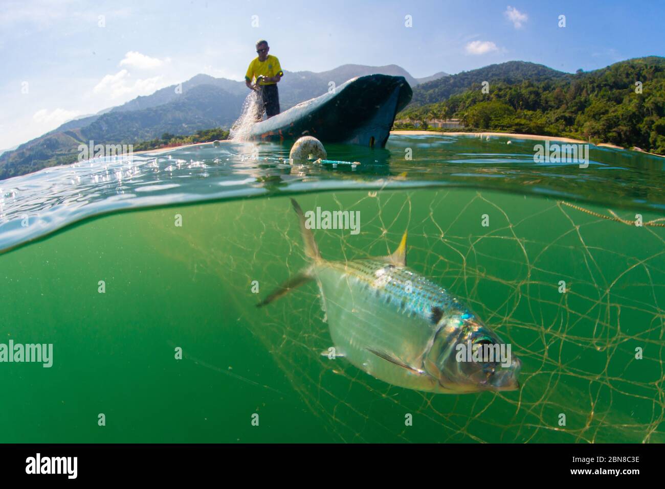 Scatto su due livelli di un tradizionale pescatore in canoa di legno sulla costa meridionale del Brasile. Foto Stock