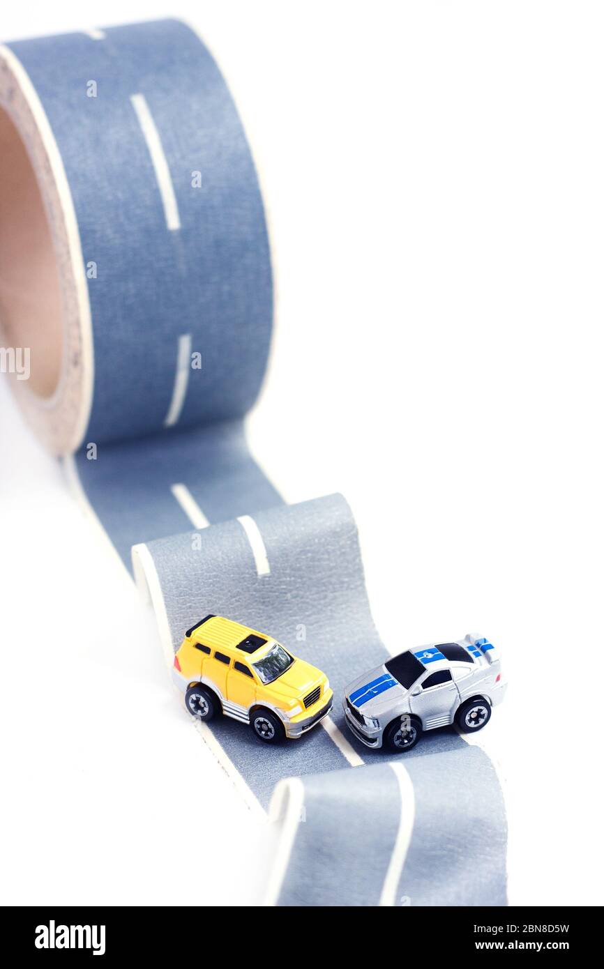 Incidente stradale. Due modelli di giocattoli su nastro per condotti. Strada sdrucciolevole o accidentata. Assicurazione. Incidente Foto Stock