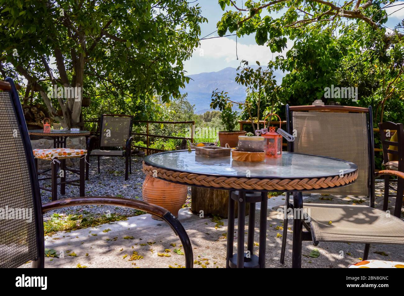 Terrazza ombreggiata con tavoli rotondi su una piccola collina a Creta, Grecia Foto Stock