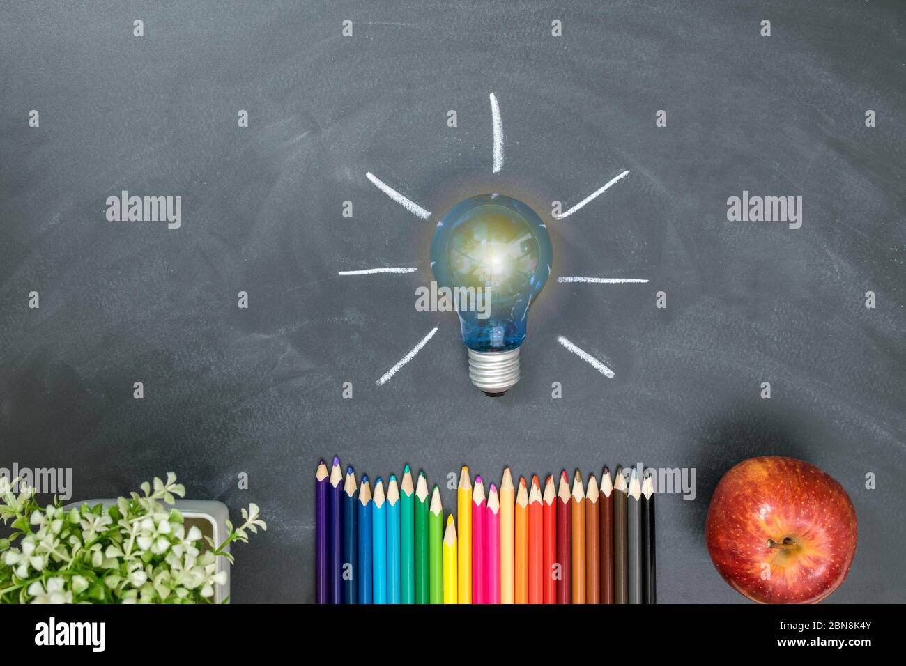 Lampada con tavola di gesso, matite colorate e mela rossa, educazione  concettuale, idee Foto stock - Alamy