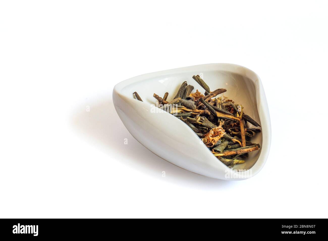 Un mucchio di rododendro essiccato Adamsia in una ciotola bianca cha Hae, Sagan ogni giorno per il tè. Isolato su uno sfondo bianco primo piano Foto Stock