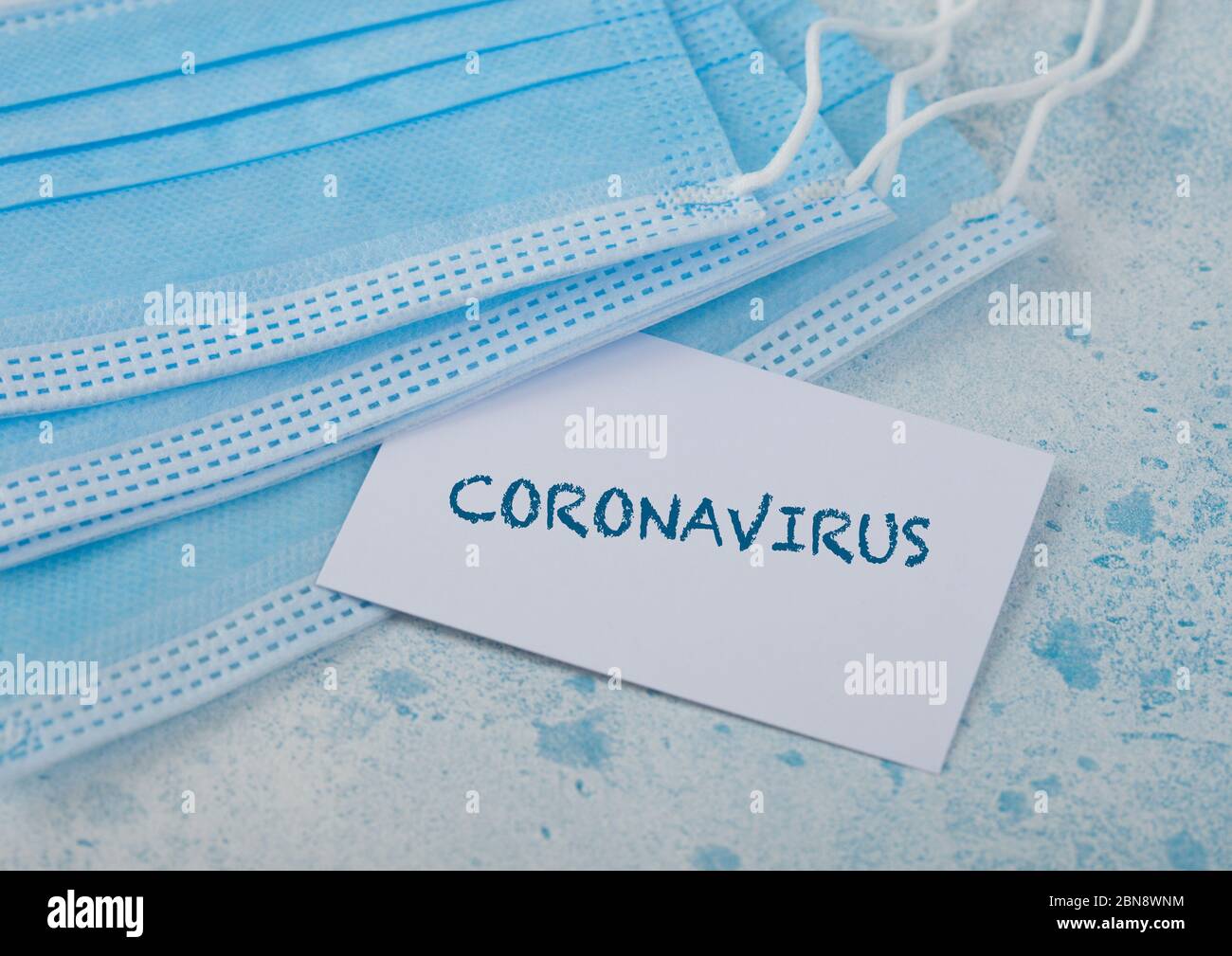 Maschera medica con cartoncino bianco su blu. Migliore protezione da coronavirus, germi, batteri e virus. Tex sulla carta: Soggiorno a Home.Coronavirus Foto Stock