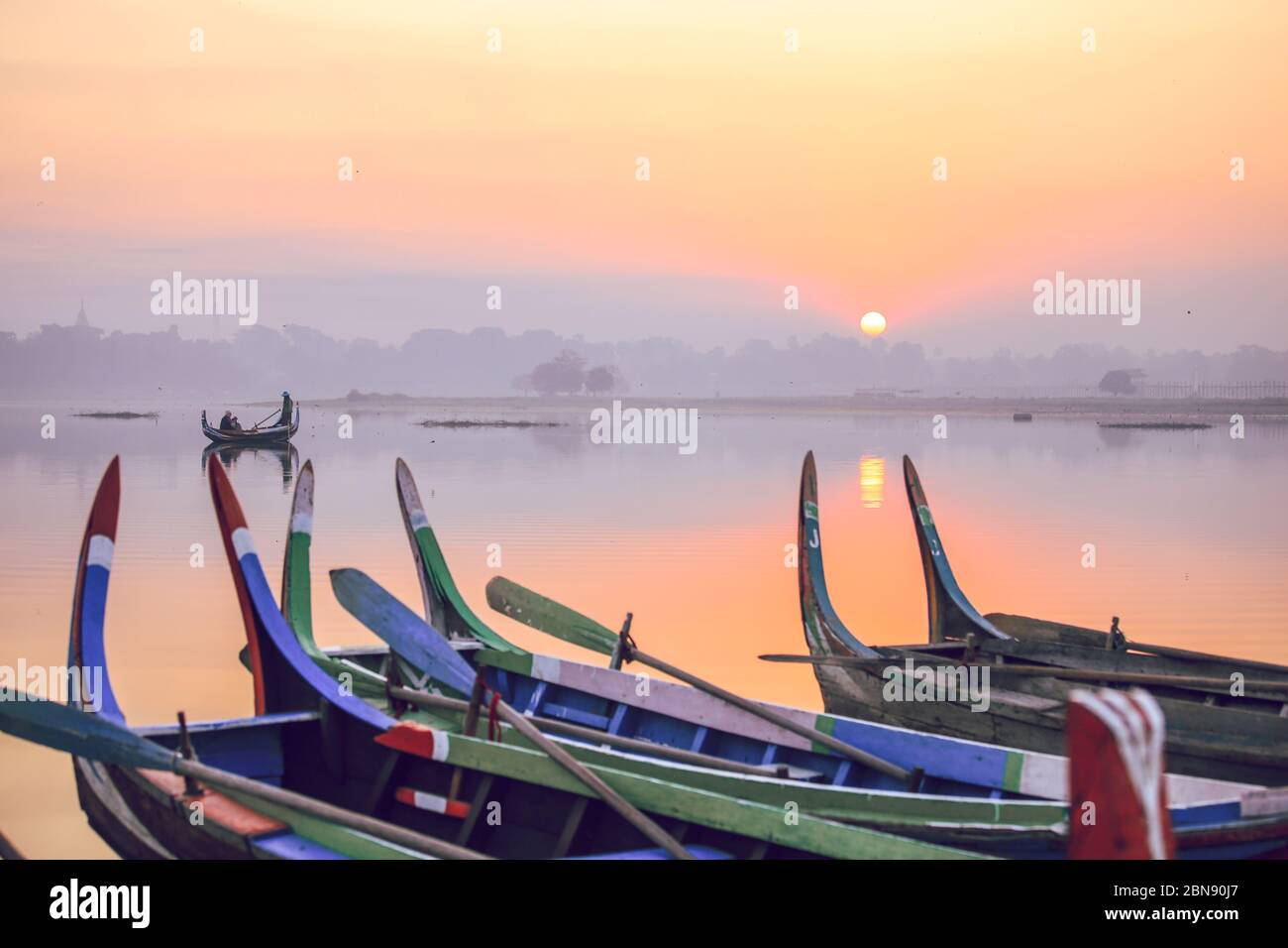 Barche colorate sulla riva con alba vicino al Ponte U Bein, Lago Taungthaman vicino Amarapura, Myanmar Foto Stock