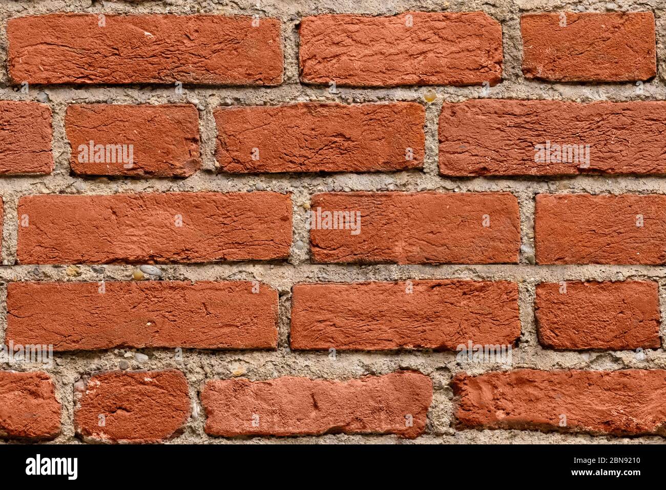 Sfondo con struttura in mattoni rosso scuro senza cuciture per il design. Modello di vecchio muro di brickwall rotto con agenti atmosferici. Muro di pietre impilate. Muro di lavoro in mattoni da vecchio Foto Stock