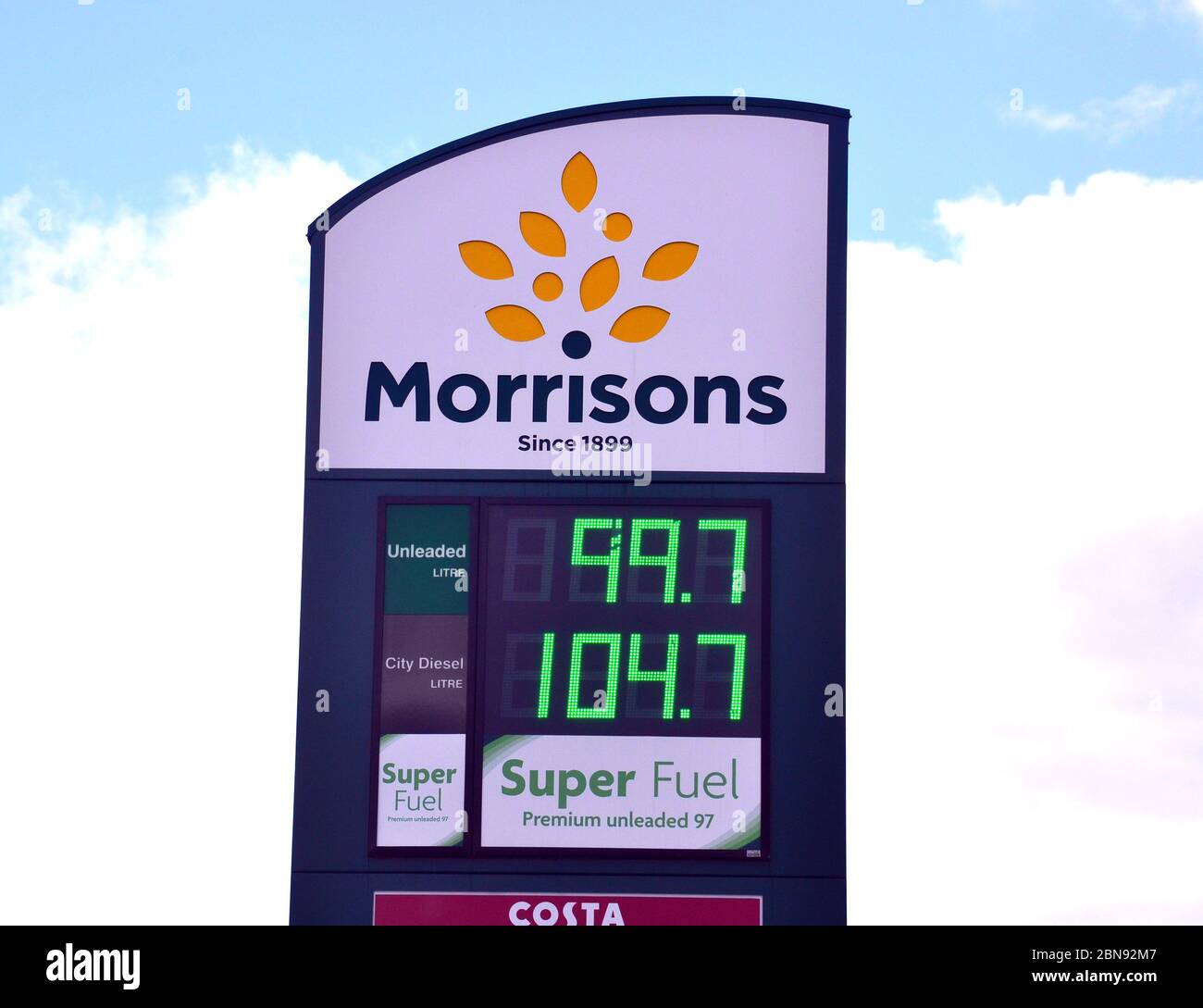 La benzina scende al di sotto di £1 litro. Un distributore di benzina Morrisons o un cartello prezzi garage a Manchester, Inghilterra, Regno Unito, 13 maggio 2020, mostra benzina senza piombo a 99.7 pence al litro. I prezzi del petrolio sono scesi nella primavera del 2020 durante la pandemia di Coronavirus o Covid 19, poiché la guida e tutte le forme di viaggio sono diminuite a livello globale. Foto Stock