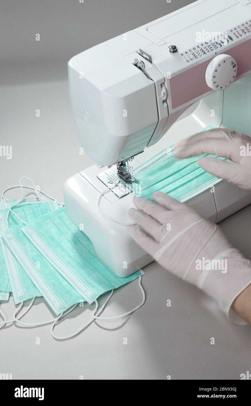 Processo di fabbricazione di maschere mediche protettive su macchina da cucire Foto Stock