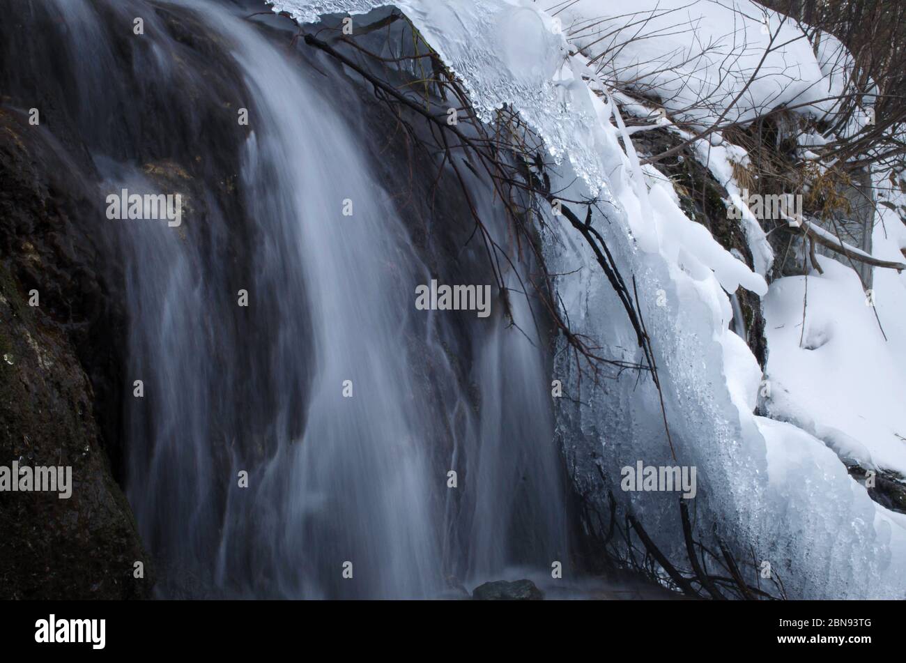 cascata in inverno in montagna e nel ghiaccio. Foto Stock