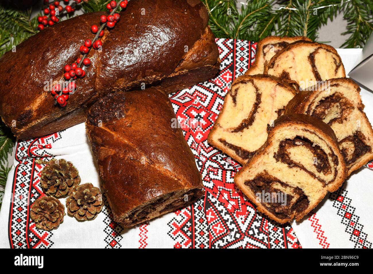 Primo piano di fette di pane tradizionale rumeno dolce fatto in casa chiamato 'cozonac', con cacao, uvetta, noci varie e patatine di cioccolato, pronto per essere mangiato Foto Stock
