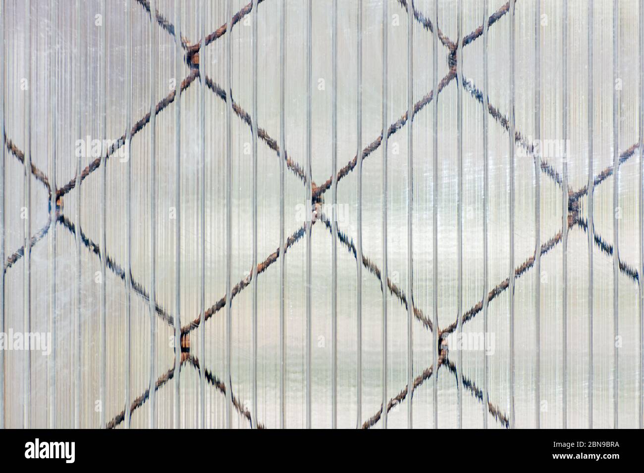 Celle di una rete di ferro che brilla attraverso la superficie cellulare di  un foglio di plastica, da utilizzare come una struttura per lo sfondo Foto  stock - Alamy