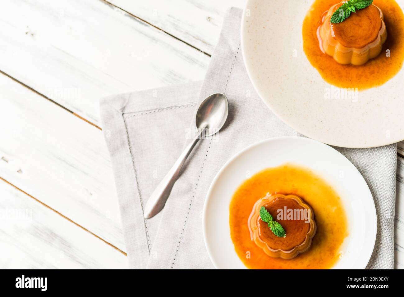 Primo piano di un budino di caramello cremore al flan con menta, un dessert alla crema. Foto Stock