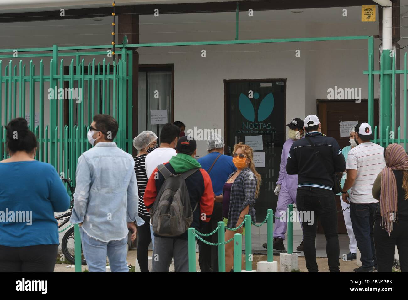 13 maggio 2020, Bolivia, Santa Cruz: Molte persone aspettano con maschere facciali di fronte ad una farmacia dove ivermectin, una droga presumibilmente efficace contro Covid-19, è venduto. Il farmaco antiparassitario è diventato la nuova speranza nel paese sudamericano dopo che i risultati di uno studio pre-clinico australiano sono stati annunciati. Dopo che i rapporti dello studio sono stati trasmessi in televisione, la gente ha fatto il loro senso alle farmacie. "Vorrei acquistarlo come precauzione. Sarà più costoso più tardi,' ha detto un uomo in piedi in linea. Nessuno nella sua famiglia aveva mostrato sintomi della malattia di Covid-19. "Mia moglie mi ha mandato qui. Siamo giusti Foto Stock