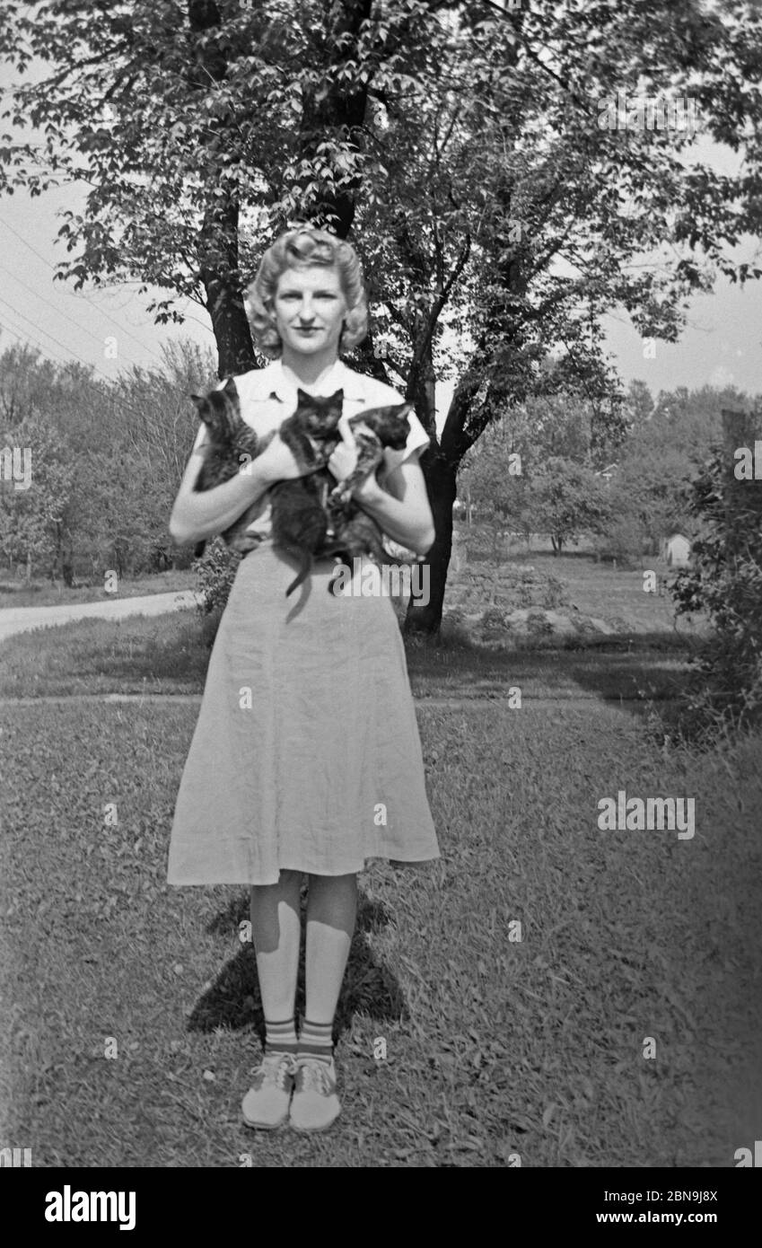 Donna che tiene i gatti tra le braccia ca. anni '40 Foto Stock