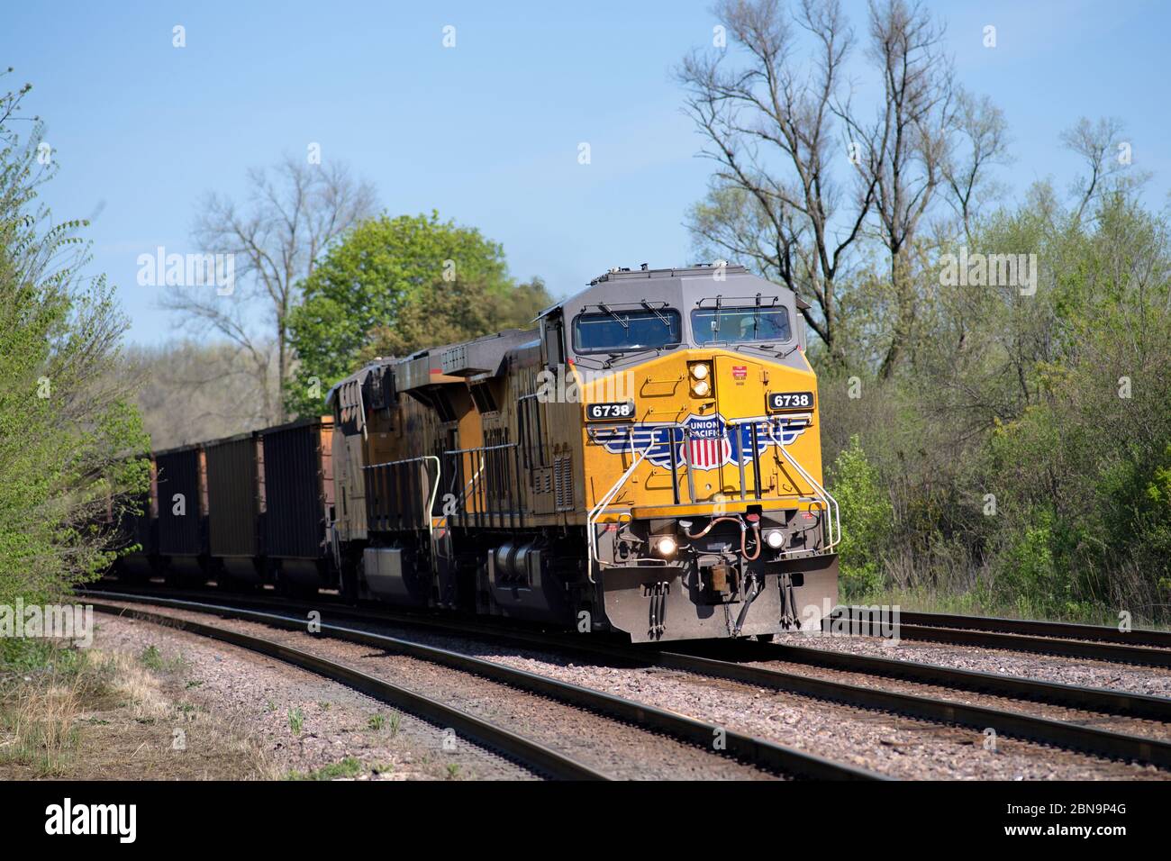 Winfield, Illinois, Stati Uniti. Due locomotive guidano un treno merci dell'Unione del Pacifico di automobili a carbone vuote intorno ad una curva e attraverso Winfield, Illinois. Foto Stock