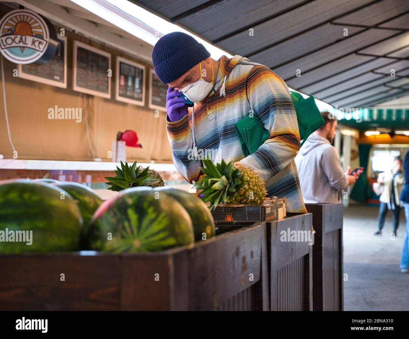 LOS ANGELES, STATI UNITI - 05 aprile 2020: Un uomo negozi di generi alimentari mentre indossa una maschera durante l'epidemia di COVID-19. Foto Stock
