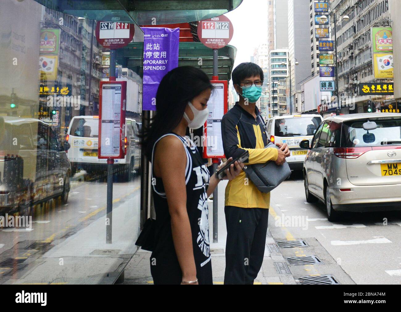 Hongkongers che indossano maschere chirurgiche durante la pandemia di Covid-19. Foto Stock