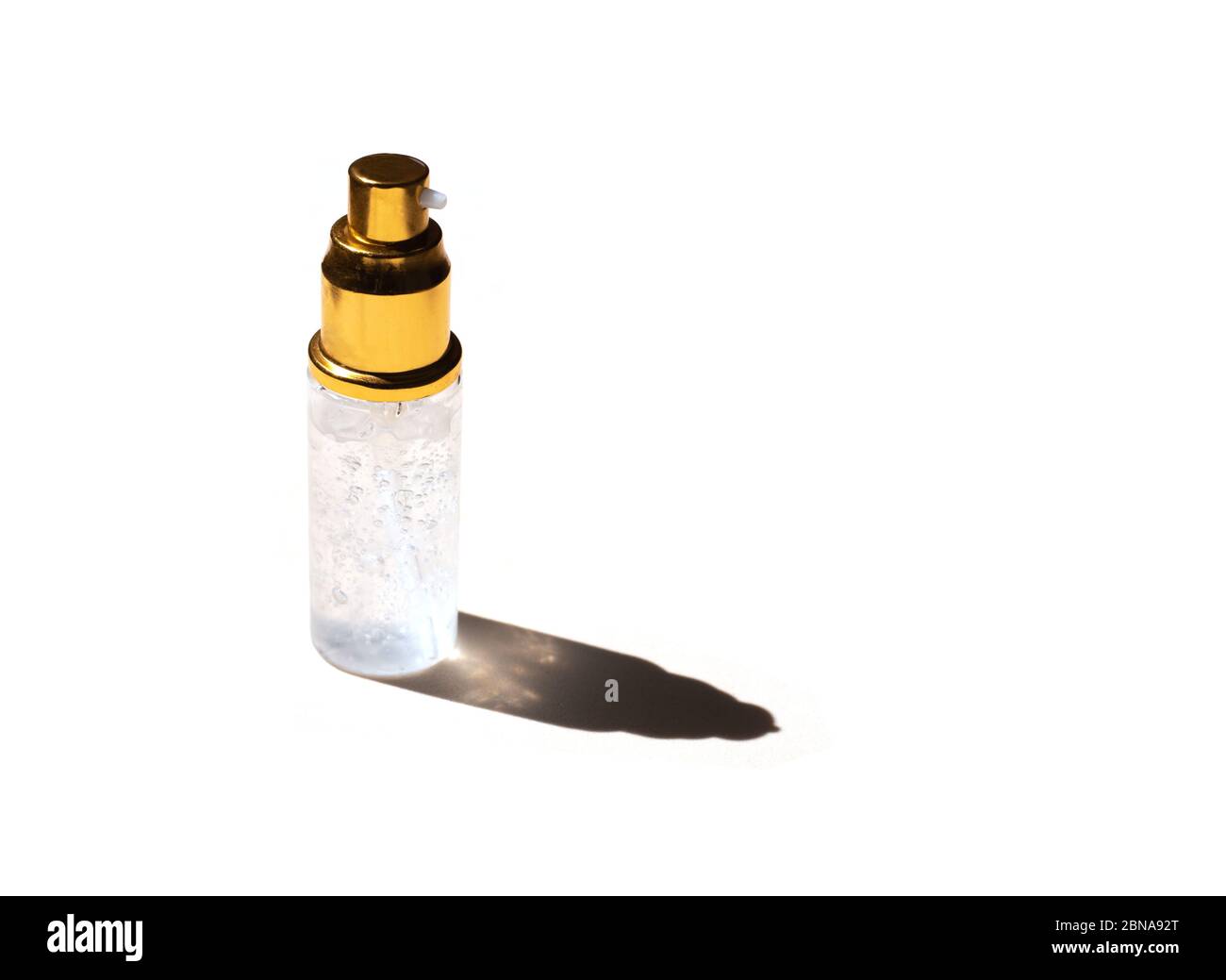 Gel trasparente igienizzante su sfondo bianco isolato con un'ombra traslucida dal sole brillante Foto Stock
