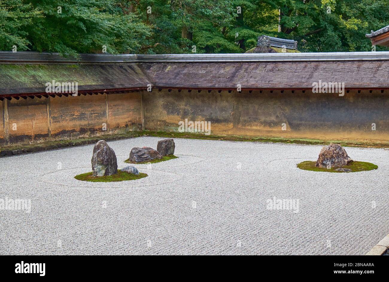 La vista di gruppi separati di massi circondati dalle onde di ghiaia bianca nel famoso giardino di pietra Zen del tempio Ryoan-ji. Kyoto. Giappone Foto Stock