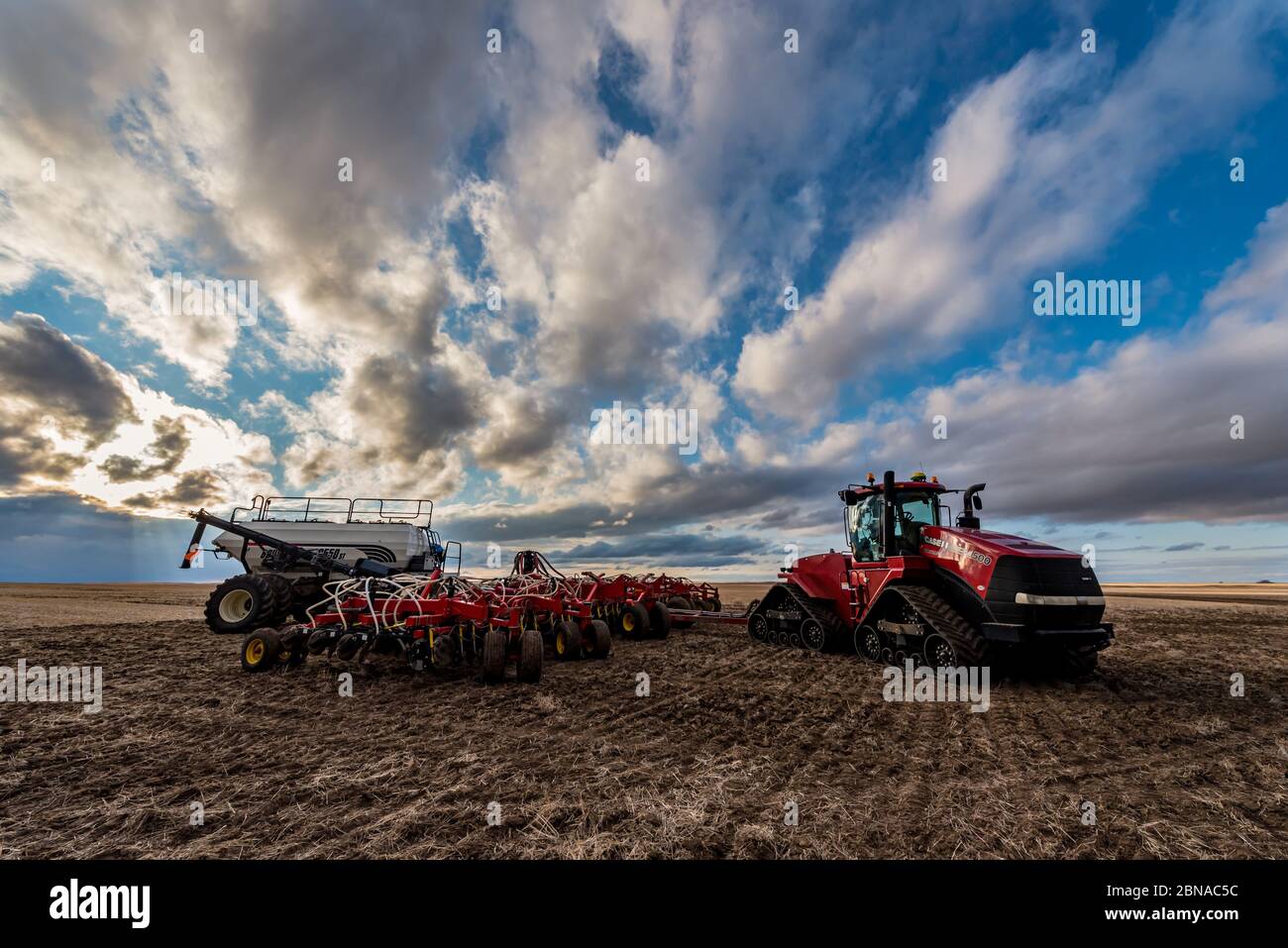 Swift Current, SK/Canada - 9 maggio 2020: Ampio cielo al tramonto sul trattore Case e sulle attrezzature di semina per perforatrici ad aria Bourgault a Saskatchewan, Canada Foto Stock