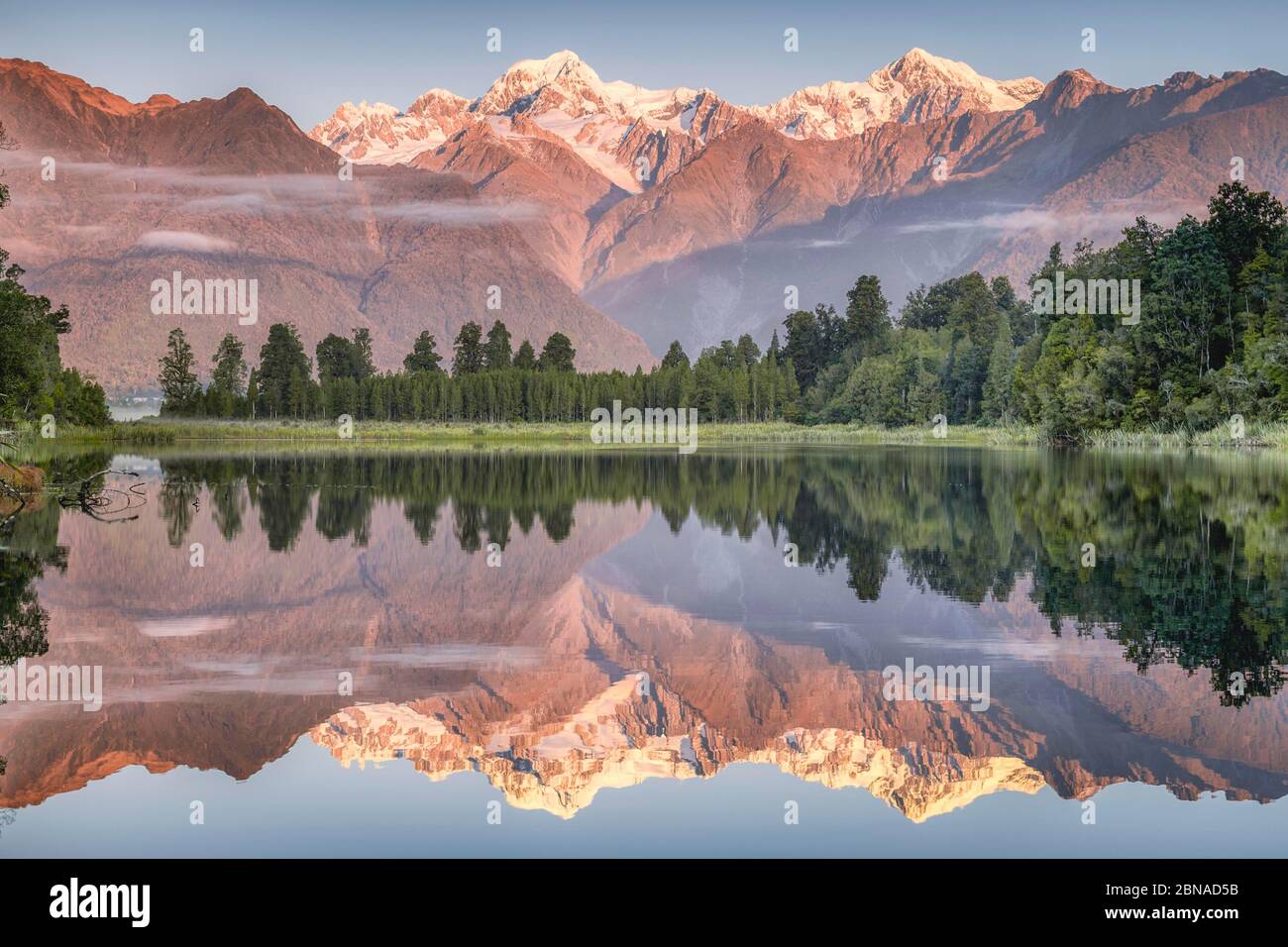 Cime innevate di Mount Cook e Mount Tasman si riflettono nel lago Matheson nella luce serale, Westland National Park, Fox Glacier, Whataroa, We Foto Stock