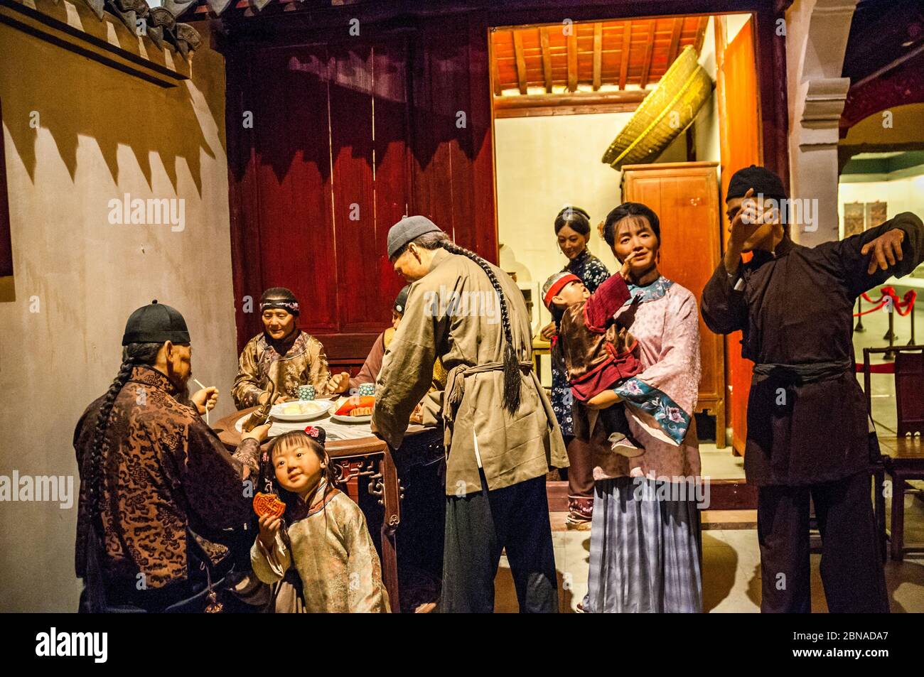 Un display da Ningbo museo che rappresenta una famiglia di Qing scena guardando la metà autunno luna e una ragazza a mangiare una torta della luna Foto Stock