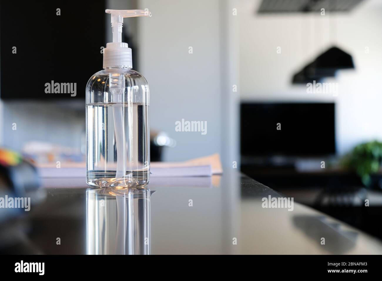 Bottiglia di igienizzatore per mani sul banco della reception dell'ufficio per aiutare a pulire le mani Foto Stock